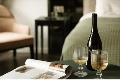 a bottle of wine and two glasses on a table at The Hobson Cambridge by Adina in Cambridge