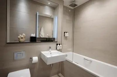 a bathroom with a sink and a toilet and a mirror at The Hobson Cambridge by Adina in Cambridge