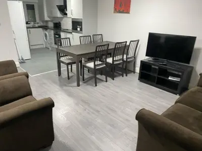 a living room with a table and chairs and a television at Bronze house in Friern Barnet