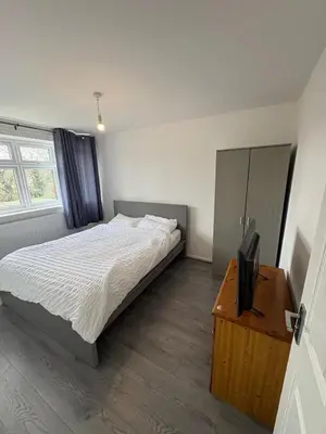 a bedroom with a bed and a flat screen tv at Bronze house in Friern Barnet