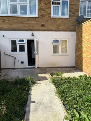 a house with a white door and a brick building at Bronze house in Friern Barnet