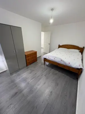 a bedroom with a bed and a dresser in it at Bronze house in Friern Barnet