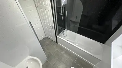 a bathroom with a toilet and a shower and a sink at Bronze house in Friern Barnet