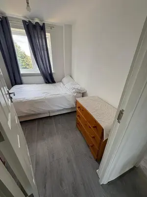 a small bedroom with two beds and a window at Bronze house in Friern Barnet