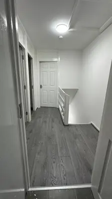an empty hallway with a door and a wooden floor at Bronze house in Friern Barnet