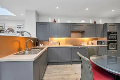 a kitchen with a sink and a table with chairs at GROUND floor apartment no steps 119 Northgate St luxury 2 bedroom apartment close to the town centre with paid parking close by in Bury Saint Edmunds
