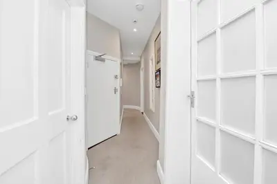 a hallway with white shelves and a door at GROUND floor apartment no steps 119 Northgate St luxury 2 bedroom apartment close to the town centre with paid parking close by in Bury Saint Edmunds