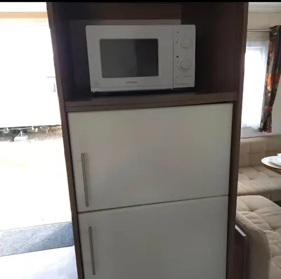 a microwave oven sitting on top of a refrigerator at Coastal Retreats in Great Clacton