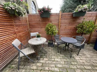 a patio with a table and chairs and a fence at Luxury Boutique 'Duchess Suite' in Historic Centre in Cambridge