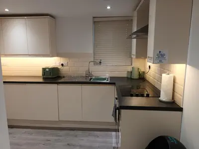 a kitchen with white cabinets and a sink at Stylish 1 Bed Flat Parking Walk to Waterfront in Ipswich