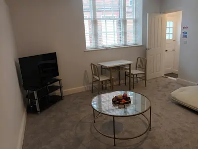 a living room with a table and a tv at Stylish 1 Bed Flat Parking Walk to Waterfront in Ipswich