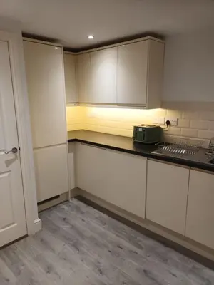 an empty kitchen with white cabinets and a stove at Stylish 1 Bed Flat Parking Walk to Waterfront in Ipswich