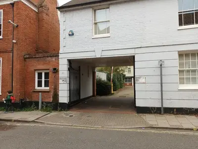 a white building with a garage in a street at Stylish 1 Bed Flat Parking Walk to Waterfront in Ipswich