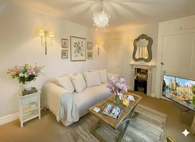a living room with a white couch and a tv at Luxury boutique 'Duke Suite' In historic centre in Cambridge