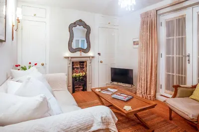 a living room with a white couch and a table at Luxury boutique 'Duke Suite' In historic centre in Cambridge