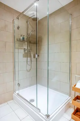 a shower with a glass door in a bathroom at Luxury boutique 'Duke Suite' In historic centre in Cambridge