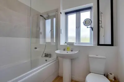 a white bathroom with a sink and a shower at Pass the Keys Stylish and Modern Flat with Free Parking in Cambridge