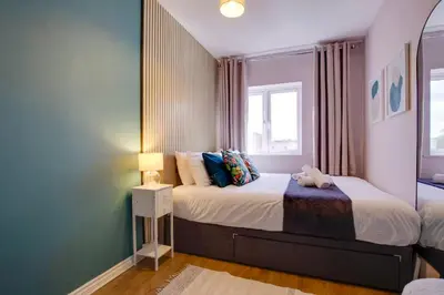 a bedroom with two beds and a window at Pass the Keys Stylish and Modern Flat with Free Parking in Cambridge