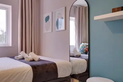a bedroom with two beds and a mirror at Pass the Keys Stylish and Modern Flat with Free Parking in Cambridge