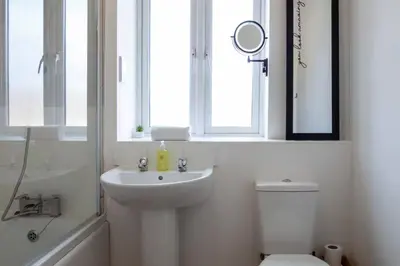 a bathroom with a sink and a toilet and a window at Pass the Keys Stylish and Modern Flat with Free Parking in Cambridge