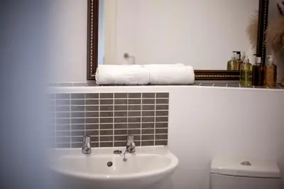a bathroom with a sink and a mirror and a toilet at Pass the Keys Stylish and Modern Flat with Free Parking in Cambridge