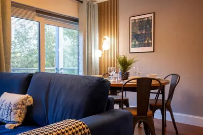 a living room with a blue couch and a table at Pass the Keys Stylish Riverside Apartment with Free Parking in Cambridge