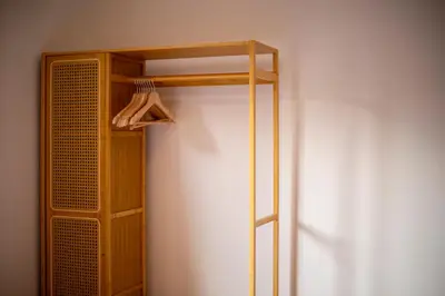 a wooden closet with a hanger and a wooden shelf at Pass the Keys Stylish Riverside Apartment with Free Parking in Cambridge