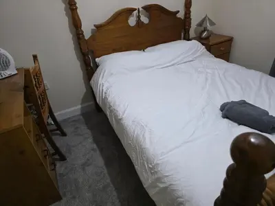 a bedroom with a white bed with a wooden headboard at Colchester Central and calm Ni in Hythe
