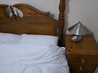 a bedroom with a bed and a lamp on a nightstand at Colchester Central and calm Ni in Hythe