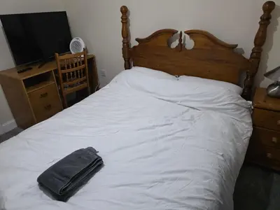 a bed with a towel on it with a television at Colchester Central and calm Ni in Hythe