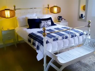 a bedroom with a white bed and a white chair at Guest Rooms at The Green Man in Takeley