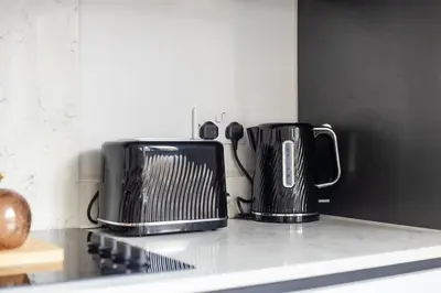 two black appliances sitting on top of a kitchen counter at Stonebridge House Apartment in Chelmsford