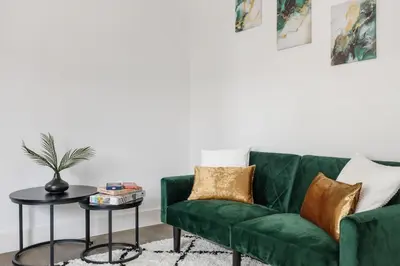 a green couch in a living room with a table at Stonebridge House Apartment in Chelmsford