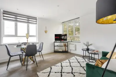 a living room with a table and chairs at Stonebridge House Apartment in Chelmsford