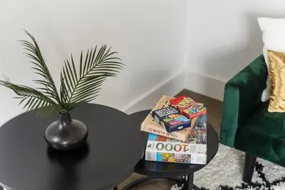 a table with a potted plant on top of it next to a chair at Stonebridge House Apartment in Chelmsford