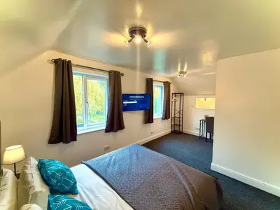 a bedroom with a bed and a window at Coastal Lodge in Leiston