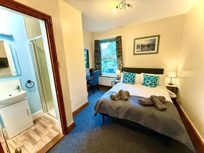 a bedroom with a bed with two towels on it at Coastal Lodge in Leiston