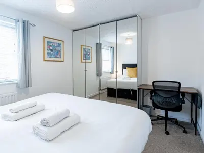 a white bedroom with a desk and a bed at Pass the Keys Cosy home Basildon Ideal for contractors in Basildon