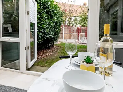 a table with a bottle of wine and two glasses at Pass the Keys Cosy home Basildon Ideal for contractors in Basildon