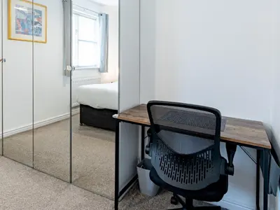 a desk with a chair in a room with a bedroom at Pass the Keys Cosy home Basildon Ideal for contractors in Basildon