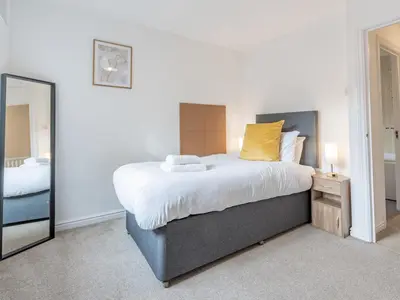 a bedroom with a large bed and a mirror at Pass the Keys Cosy home Basildon Ideal for contractors in Basildon