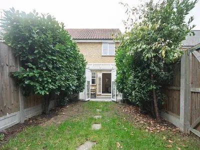 a house with two trees in front of a fence at Pass the Keys Cosy home Basildon Ideal for contractors in Basildon