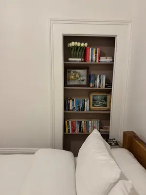 a living room with a couch and a book shelf at Bright & Stylish 3-Bedroom Flat in Ipswich
