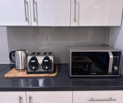 a kitchen counter with a toaster and a microwave at Bright & Stylish 3-Bedroom Flat in Ipswich