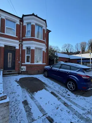 a blue car parked in front of a brick house at Bright & Stylish 3-Bedroom Flat in Ipswich
