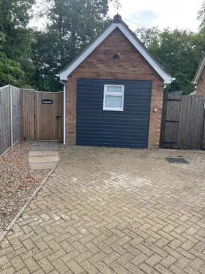 a garage with a door on the side of it at Woodland View in East Harling