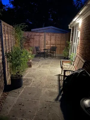 a patio at night with chairs and a table at Woodland View in East Harling