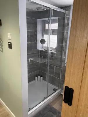 a shower with a glass door in a bathroom at Woodland View in East Harling