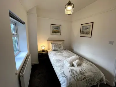 a small bedroom with a bed in the corner at Cottage Stay in Hingham in Hingham