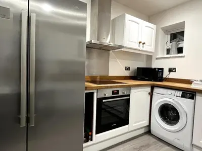 a kitchen with a refrigerator and a washer and dryer at Cottage Stay in Hingham in Hingham
